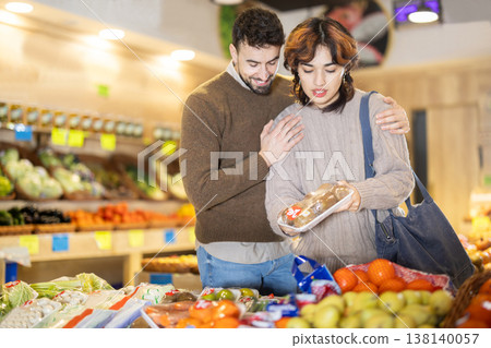 Young couple choosing kiwi in grocery store Young couple choosing kiwi in grocery store 138140057