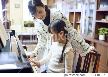 一位老師和一位女學生正在鋼琴工作室上鋼琴課。 一位老師和一位女學生正在鋼琴工作室上鋼琴課。 138140114