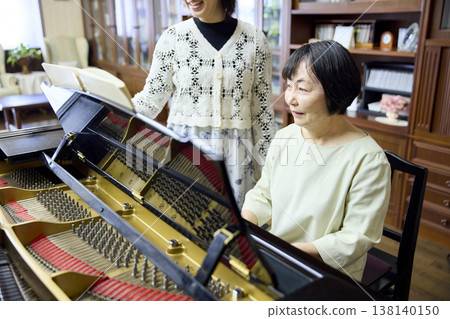 一位精神矍鑠的老年婦女正在學習鋼琴。 138140150