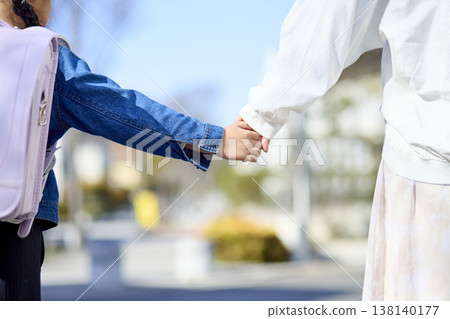 特寫鏡頭拍攝了一對母女,她們都背著書包,手牽手去上學。 特寫鏡頭拍攝了一對母女,她們都背著書包,手牽手去上學。 138140177