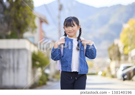 一個背著書包、微笑的小學生女孩。 138140196