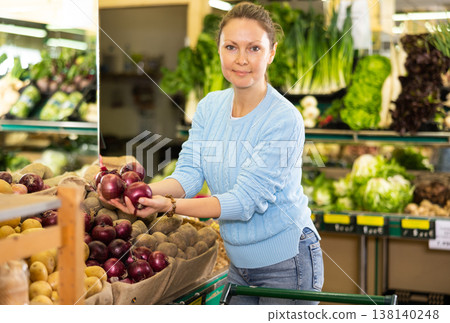 woman buy large onion in supermarket 138140248