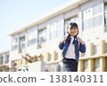 一個背著書包的小學生小女孩放學回家。 138140311