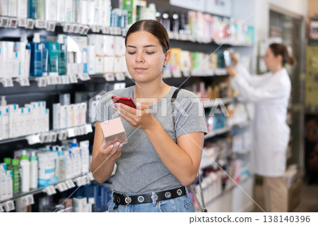 Young woman looking for cosmetic product from photo on internet Young woman looking for cosmetic product from photo on internet 138140396