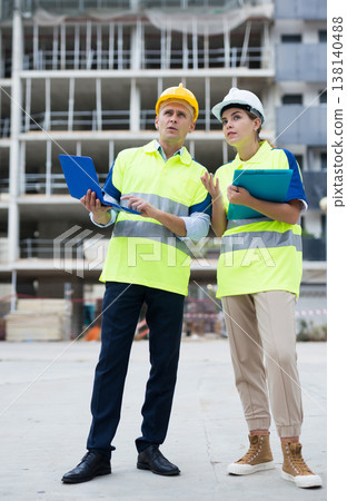 Two architects with laptop discussing construction plan Two architects with laptop discussing construction plan 138140488