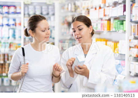 Woman pharmacist helping woman customer to choose remedy in pharmacy Woman pharmacist helping woman customer to choose remedy in pharmacy 138140513