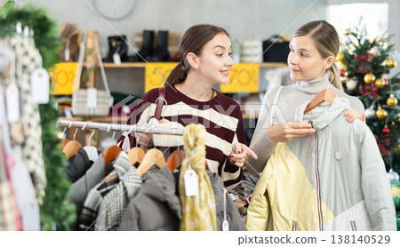 Two women choosing a coat or jacket together in a clothing store for Christmas Two women choosing a coat or jacket together in a clothing store for Christmas 138140529