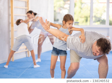 Father teaches his little daughter to use forceful techniques and grips during self defense classes Father teaches his little daughter to use forceful techniques and grips during self defense classes 138140532