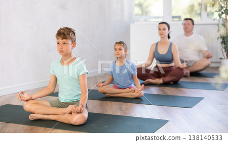 Family with two children doing yoga in studio Family with two children doing yoga in studio 138140533