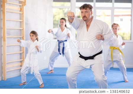 Man practicing kata routine during join family training at karate class 138140632