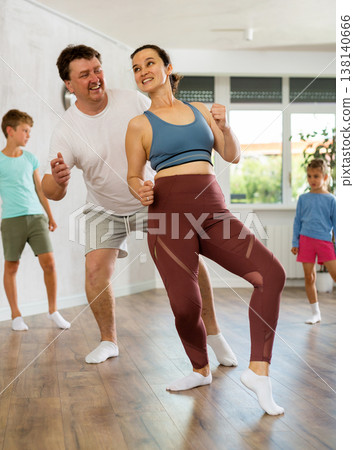 Parents with young daughter and schoolboy son are taught to move to boogie-woogie Parents with young daughter and schoolboy son are taught to move to boogie-woogie 138140666