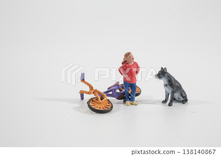 Miniature Figure and Dog Standing Beside Fallen Bicycle Miniature Figure and Dog Standing Beside Fallen Bicycle 138140867