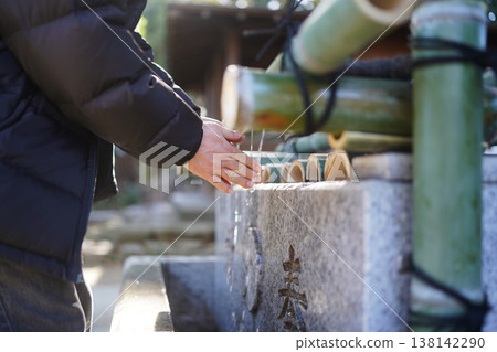 Image of a man purifying his hands at a water basin. 138142290