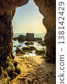 Golden hour sand beach seen through ancient arch rock formation Algarve Portugal 138142429