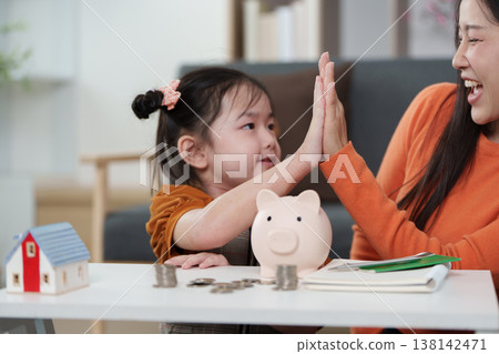 Mother and daughter celebrating financial learning success Mother and daughter celebrating financial learning success 138142471