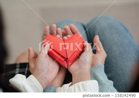 Hands holding origami heart symbolizing love and care Hands holding origami heart symbolizing love and care 138142490