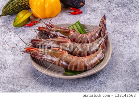 Fresh raw giant red prawns on a plate with chili peppers and tropical vegetables. Fresh raw giant red prawns on a plate with chili peppers and tropical vegetables. 138142568
