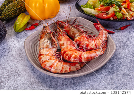 Grilled giant red prawns in a pan with fresh avocado, bell pepper, and salad on a stone table Grilled giant red prawns in a pan with fresh avocado, bell pepper, and salad on a stone table 138142574