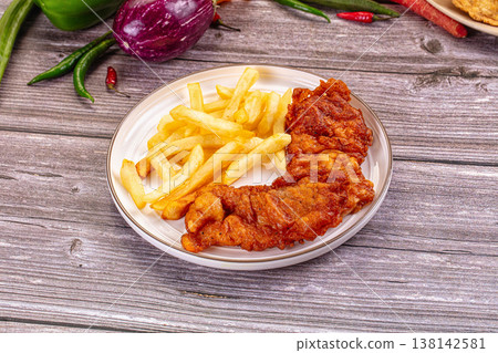 Crispy Fried Fish Fillets and French Fries on a Rustic Wooden Table with Fresh Vegetables Crispy Fried Fish Fillets and French Fries on a Rustic Wooden Table with Fresh Vegetables 138142581