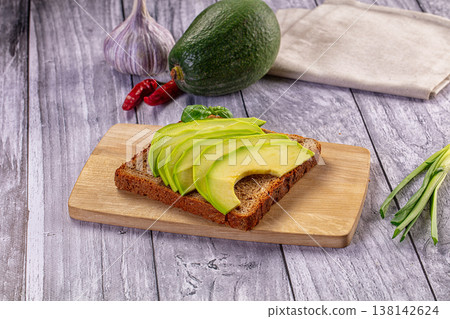 Fresh avocado toast on rye bread with whole ingredients on a rustic wooden table 138142624