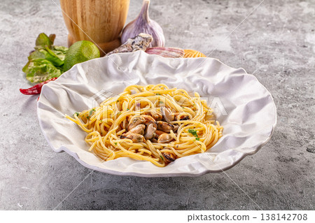 Gourmet seafood pasta with mussels, garlic, and chili served on a textured plate 138142708