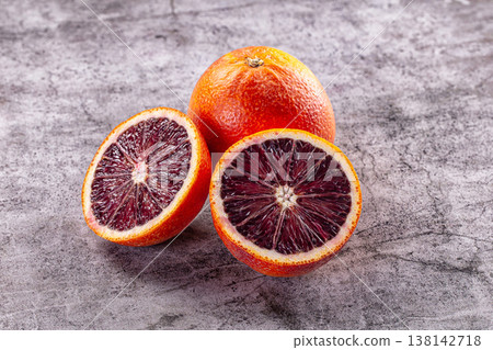 Fresh whole and sliced blood oranges on a grey textured background. Fresh whole and sliced blood oranges on a grey textured background. 138142718