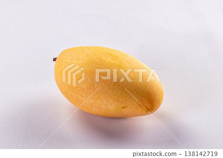 Ripe yellow mango fruit on a clean white textured background. 138142719