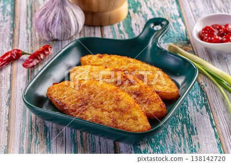 Fried potato pancakes with garlic, chili, and sauce on a rustic wooden table. Fried potato pancakes with garlic, chili, and sauce on a rustic wooden table. 138142720