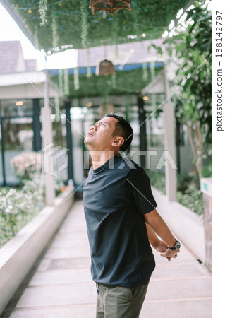 Casual man stretching body with hands on waist in outdoor environment Casual man stretching body with hands on waist in outdoor environment 138142797
