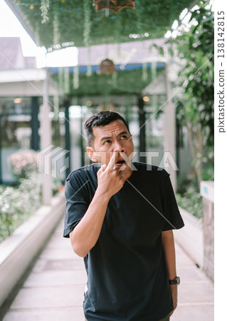 Man picking nose showing bad habit or hygiene concept in casual setting 138142815