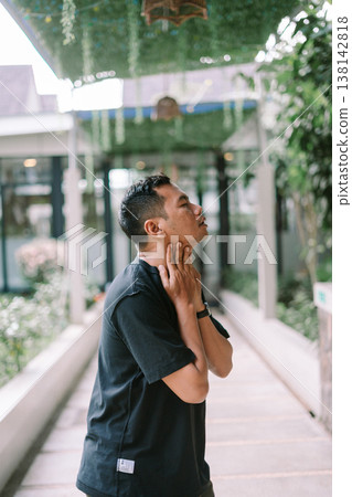 Young man suffering from neck pain touching neck with discomfort Young man suffering from neck pain touching neck with discomfort 138142818
