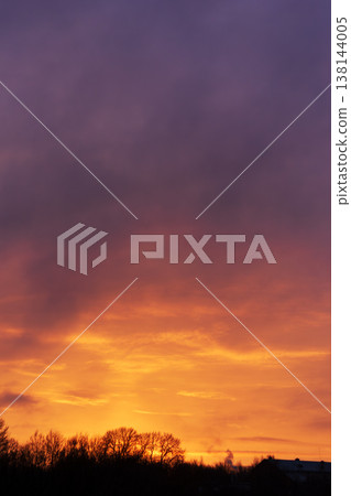 Vibrant sunset twilight sky with dramatic clouds and glowing orange and purple colors 138144005