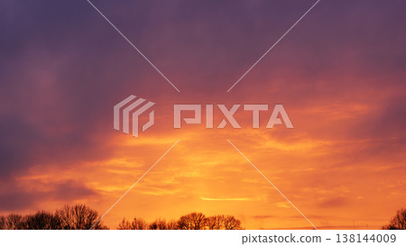 Beautiful sunset sky with vibrant orange glow and purple clouds 138144009