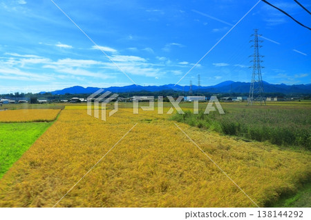 Scenery from the window of the Joshin Electric Railway: Golden rice fields and rice paddies in autumn, a clear October day on a local line in Tomioka City, Gunma Prefecture. 138144292