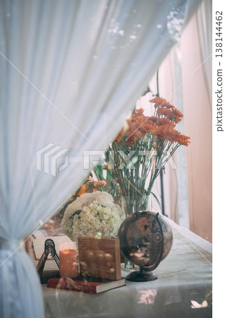 Elegant Wedding Table Decor with Vintage Globe, Flowers, and Soft Curtain Overlay Elegant Wedding Table Decor with Vintage Globe, Flowers, and Soft Curtain Overlay 138144462