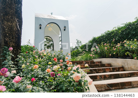 Elegant White Garden Pavillion Surrounded by Blooming Rose Bushes 138144463