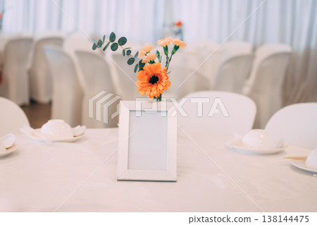 Blank Picture Frame Mockup on Wedding Table with Orange Gerbera Flower Blank Picture Frame Mockup on Wedding Table with Orange Gerbera Flower 138144475