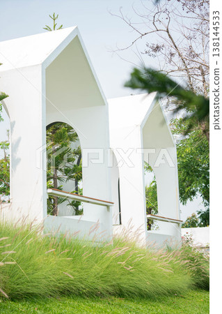 Modern White Minimalist Pavilion Architecture on Green Hill with Grass Flowers Modern White Minimalist Pavilion Architecture on Green Hill with Grass Flowers 138144533
