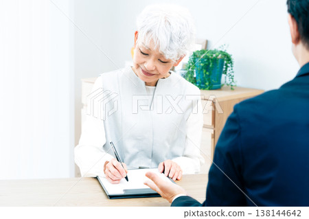 Senior woman listening to a salesperson's explanation Senior woman listening to a salesperson's explanation 138144642
