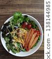 Fresh Mixed Salad Bowl with Lettuce, Crab sticks, Carrot Strips, Corn, Leafy Greens, and Assorted Vegetables Arranged in a White Round Dish 138144985
