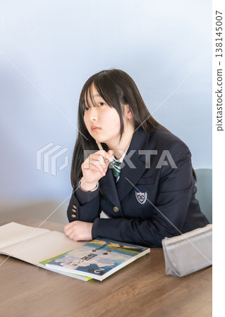 A female student in a uniform thinking deeply A female student in a uniform thinking deeply 138145007