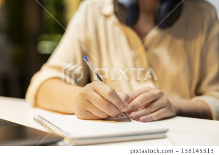Close up of employee doing overtime and transcribing key points, writing information on a textbook. Creating summary, proofreading numbers and designing strategy to align with targets. 138145313
