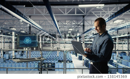 Data center engineer monitors machine learning process with laptop, reviewing operational metrics. IT specialist reviews neural networks reports during inspection to verify ongoing stability, camera A 138145369
