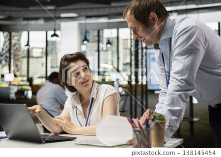 Supervisor and staff member analyzing charts and preparing reports at office desk. White man sharing insights with female coworker, refining business strategies and boosting innovation in company. Supervisor and staff member analyzing charts and preparing reports at office desk. White man sharing insights with female coworker, refining business strategies and boosting innovation in company. 138145454