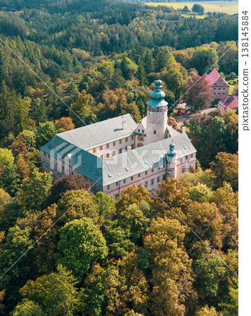 Lemberk castle stands majestically among colorful autumn foliage. This aerial perspective highlights the impressive architecture and the surrounding forest landscape. Lemberk castle stands majestically among colorful autumn foliage. This aerial perspective highlights the impressive architecture and the surrounding forest landscape. 138145884