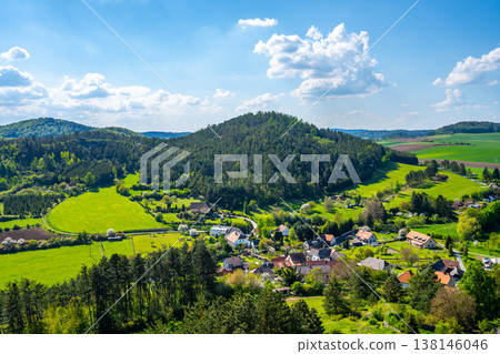 Rabi Castle offers a view of the surrounding landscape in Bohemia. Green hills and fields stretch into the distance with small houses nestled below. Clouds float in the blue sky. Rabi Castle offers a view of the surrounding landscape in Bohemia. Green hills and fields stretch into the distance with small houses nestled below. Clouds float in the blue sky. 138146046