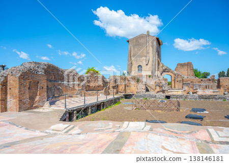 Visitors explore Casina Farnese at the Roman Forum in Rome, Italy. The historic site features ancient ruins and remains surrounded by blue skies and clouds. People walk around and take pictures. Visitors explore Casina Farnese at the Roman Forum in Rome, Italy. The historic site features ancient ruins and remains surrounded by blue skies and clouds. People walk around and take pictures. 138146181