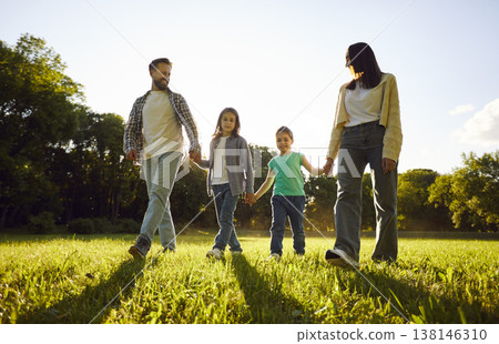 Portrait of happy smiling family with two children boy and girl walking in the field together. Portrait of happy smiling family with two children boy and girl walking in the field together. 138146310