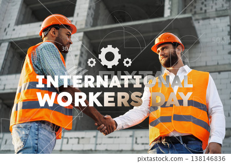 Workers celebrate International Workers Day with handshake and orange helmets on construction site Workers celebrate International Workers Day with handshake and orange helmets on construction site 138146836