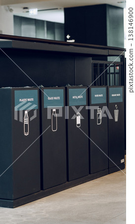 Bins for sorting waste at a recycling station in a modern building during the day Bins for sorting waste at a recycling station in a modern building during the day 138146900